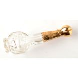 A cut glass perfume bottle with gold top.