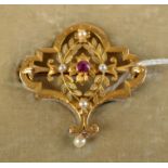 A  matt engraved gold Belle Epoch brooch with a ruby and pearls.