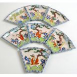 A set of seven Yixing, segment shaped hors d'oeuvres dishes, each enamelled with figures in a