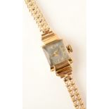 A ladies, square, gold cased Marvin wristwatch on gold bracelet.  Condition Report: weight - 15