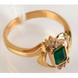 An 18ct. gold ring set emerald and diamonds.