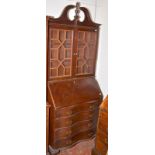 A reproduction American Chippendale bureau bookcase with serpentine front.