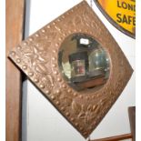 A circular mirror in Arts and Crafts brass hammered square frame. 46cm.