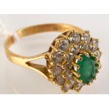 An 18ct. gold green and white stone ring.