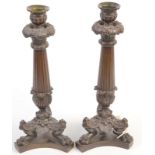 A pair of Regency bronze candlesticks after the antique with fluted columns and tripod lions' paw