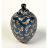 A fine Japanese cloisonne lidded jar with butterflies on a blue ground, damage,