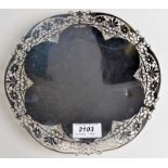 A circular silver shallow dish with pierced foliate decoration, by Gladwin Ltd.