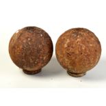 A pair of cast iron ball finials on circular bases, each diameter 20cm.