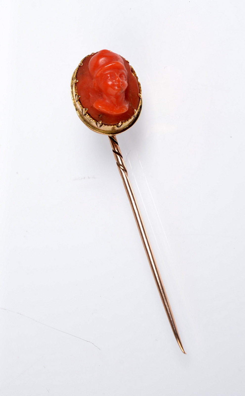 A coral cameo gold stick pin.