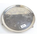 A Victorian circular silver salver engraved with a floral design and resting on three ball and claw