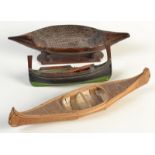 An Inuit birch bark model canoe and two other boat models.