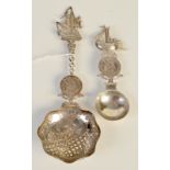 Two 19th century Dutch novelty spoons, each set with a coin and with ship finial.