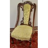 A Victorian carved nursing chair on cabriole legs with pierced back.