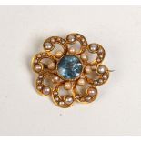 A gold, aquamarine and pearl swirl brooch.