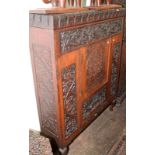 An ornately carved oak side cabinet.