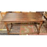 An oak table in 17th century style on plain turned, tapering supports with low stretchers,