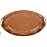 A Newlyn copper oval, pierced gallery, twin handled tray with a border of fish, seaweed and