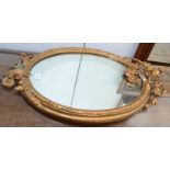 A gilt oval mirror.