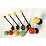 A set of four 1950s iron wall mounted coat hooks each with coloured ball terminals together with a