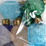 Six pressed coloured glass scent bottles decorated with flowers and fans.