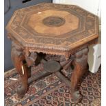 An Indian carved occasional table with elephant head supports.