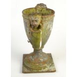 A cast iron vase with twin ring mask handles on square base. Condition Report: Height 44cm.
Rusty.