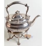 A half fluted tea kettle on a spirit burner stand with lions paw cast feet.