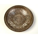 A Middle Eastern bronze dish inlaid with silver kufik script, diameter 23.3cm.