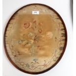 A late 18th century oval floral embroidered panel in a mahogany frame.