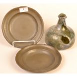 A pair of small pewter plates together with a glass onion form bottle, damaged.