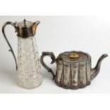 A cut glass claret jug with a plated mount and an oval lobed teapot.