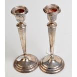 A pair of silver table candlesticks with tapering stems and spreading circular bases, height 20.5cm.