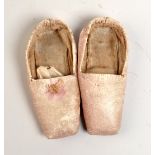 A pair of miniature pink leather slippers.