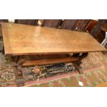 An oak refectory dining table on pierced lathe shaped supports with low stretcher,