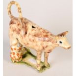 A rare early "Wheildon" hobbled cow creamer splashed with brown,