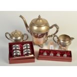 A three piece tea service, together with napkin rings and name card holders.