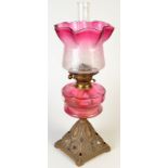 An oil lamp with cranberry etched glass shade and cut cranberry fount. Condition Report: The shade