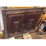 A carved oak 19th century side cabinet with two panelled doors, width 122cm, height 105.5cm.