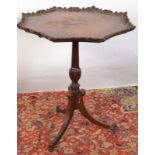 A tripod table with ornate carved, octagonal top.