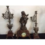 A continental red marble and cast white metal candelabra garniture, the clock mounted with two