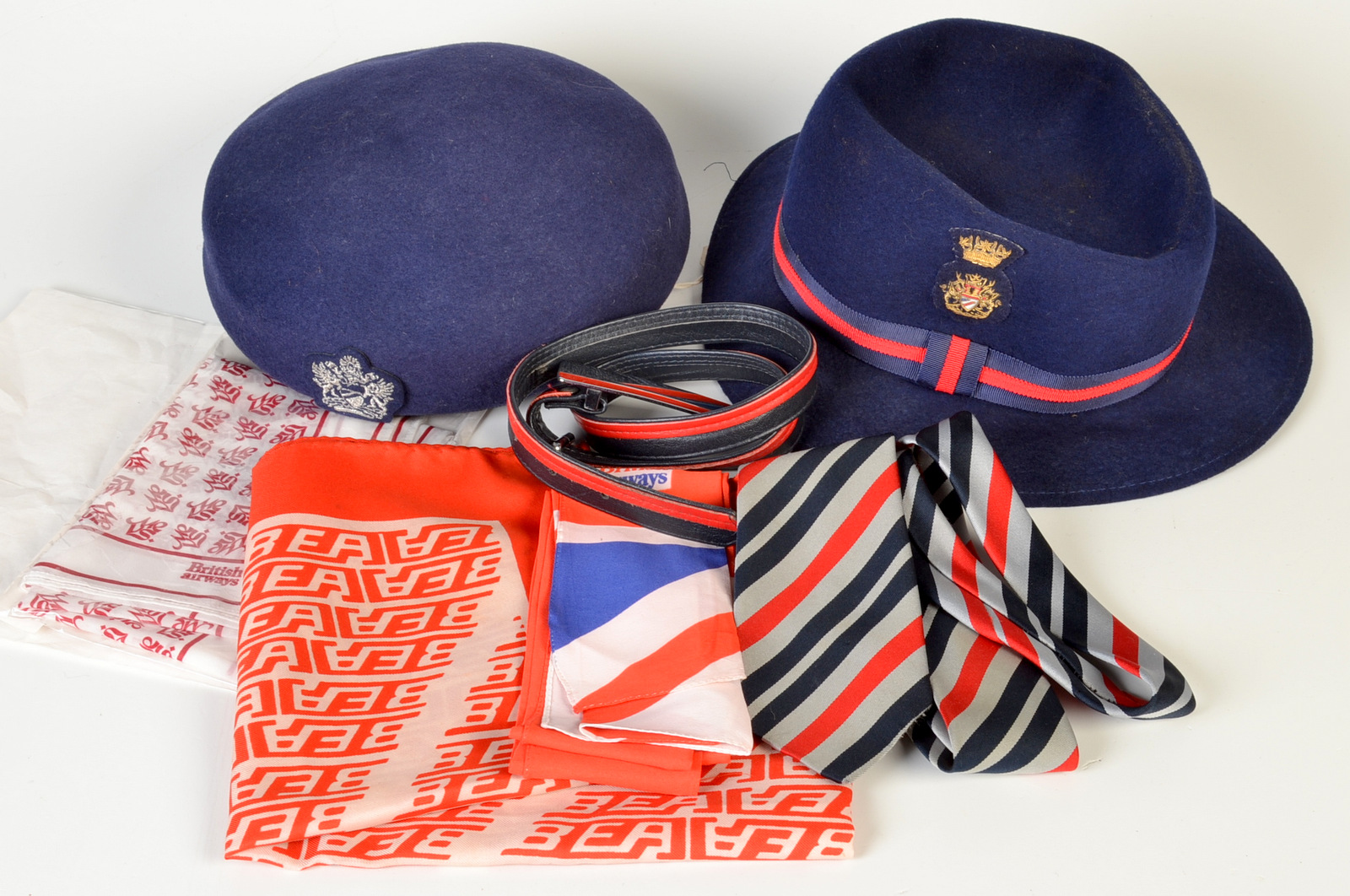 Two British Airways cabin staff hats, together with a related tie, belt etc.