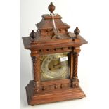A continental walnut case mantle clock, with a brass dial in an architectural case.