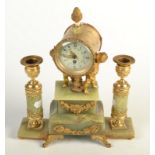 An ormalu and onyx clock garniture, the timepiece supported by cherubs flanked by candlesticks.