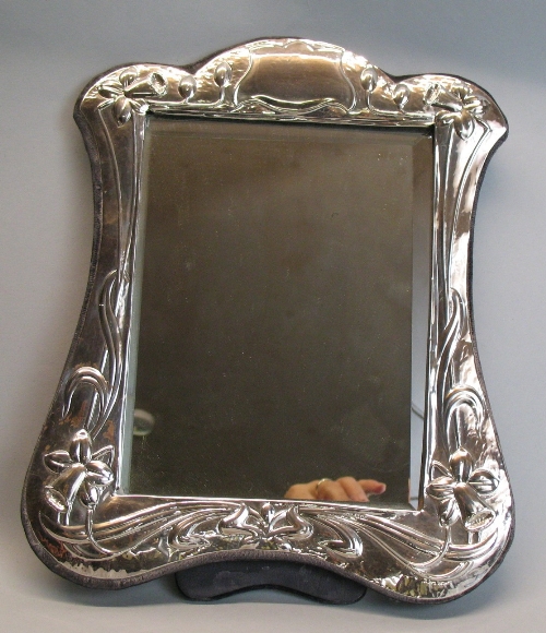 A toilet mirror, having oblong bevel edged plate in hammered surround with Art Nouveau style