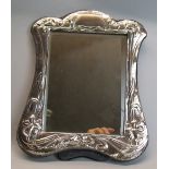 A toilet mirror, having oblong bevel edged plate in hammered surround with Art Nouveau style