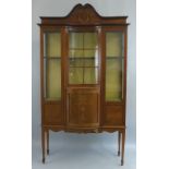 An Edwardian mahogany and inlaid display cabinet, having arched pediment over a flared cornice and