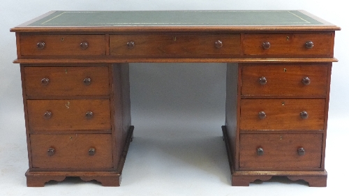 A mahogany pedestal desk, having leather writing surface over three frieze drawers on two banks of