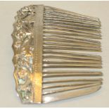 A Chinese white metal hair comb, of slightly curved form, moulded and pierced with stylised