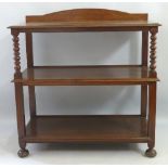 An early 20th Century oak buffet, having arched back over three tiers on bobbin turned and block