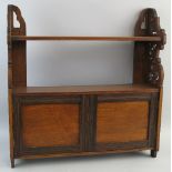 An early 20th Century walnut cupboard, wall mounting with pierced sides and single open shelf over